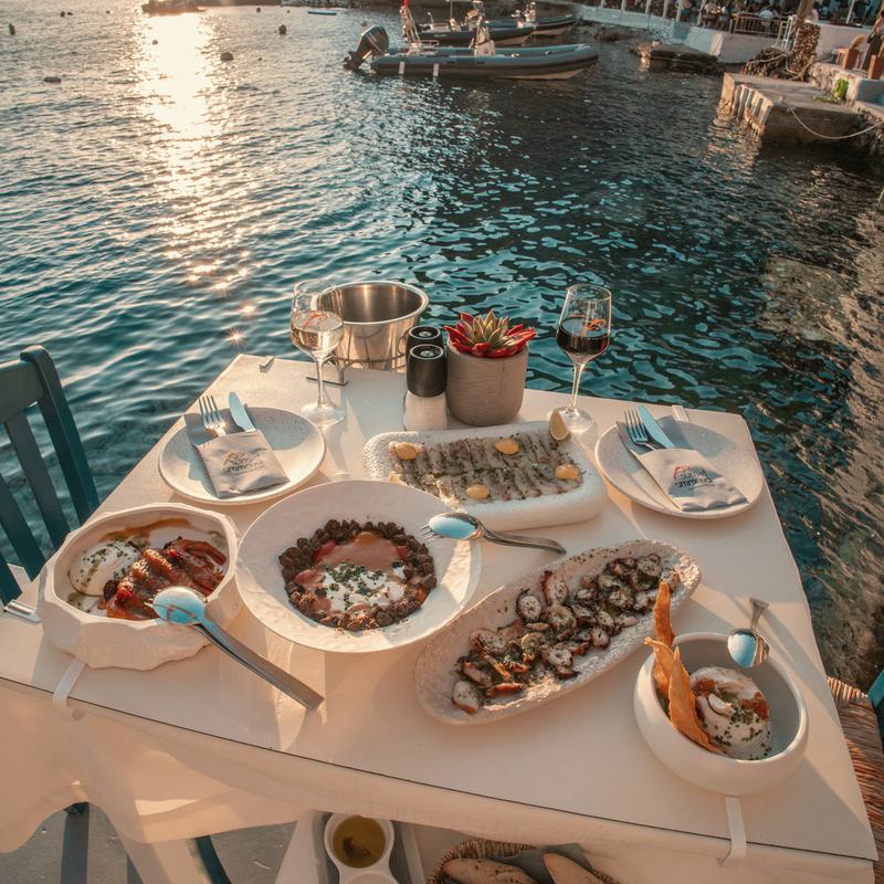Gedeckter Tisch mit Meeresfrüchten direkt am Hafen bei Abendlicht